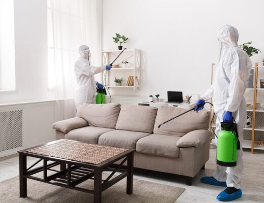 Dwie osoby dezynfekuja pokój w mieszkaniu