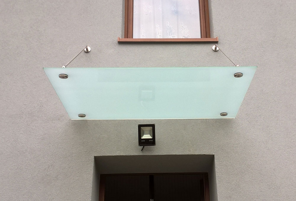 minimalistyczny szklany daszek nad drzwiami domu